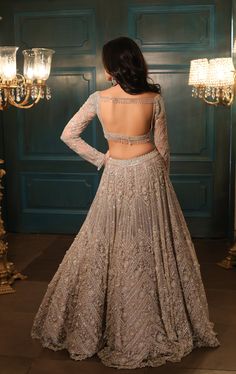 This metallic nude grey lehenga features all-over sequin, crystal, pearls, and cutdana embroidery. Paired with a corseted full sleeves blouse and an embroidered dupatta in net.DELIVERY TIMEPlease allow 8-12 weeks for your outfit to arrive.FABRIC DETAILSNetProfessional cleaning only. Full Sleeves Blouse For Saree, Lehenga Back Neck Design, Back Design For Lehenga Blouse, Lengha Blouse Designs Back, Lengha Blouse Designs Full Sleeves, Full Sleeves Lehenga Blouse, Net Blouse Designs Back, Full Sleves Desine Blouses Latest, Full Sleeve Lehenga Blouse