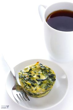 a white plate topped with a muffin next to a cup of coffee