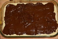 a chocolate cake in a glass dish on a wooden table