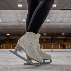 a person is skating on an ice rink with their feet in the air and one leg up