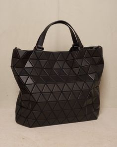 Easy large tote bag by Bao Bao Issey Miyake in black. Large carry-all tote with detachable shoulder strap in cowhide leather. Matte triangular tiles tessellate the exterior surface with a matte leather-like finish. Large internal capacity with secure pockets and nylon lining. Synthetic Leather, Polyester, Cowhide Leather.Made in Japan. Triangle Shoulder Bag With Removable Pouch For Travel, Modern Triangle Bag With Removable Pouch, Black Geometric Bag For Everyday Use, Modern Triangle Bag For Daily Use, Modern Triangular Shoulder Bag For Shopping, Modern Black Geometric Bags, Luxury Geometric Shoulder Bag With Removable Pouch, Modern Triangle Shopping Bag, Modern Triangle-shaped Shopping Bags