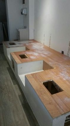 an unfinished kitchen counter is being installed in a room with wood floors and white walls