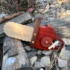 a wooden toy knife laying on top of some rocks