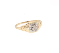 a yellow gold ring with a white diamond in the center, on a white background