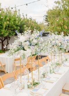 a long table with white and blue flowers on it