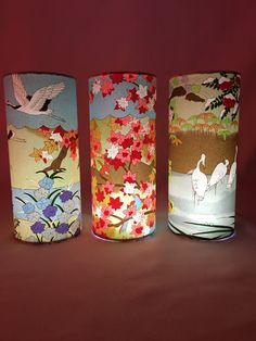 three vases with different designs on them sitting side by side in front of a red background