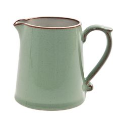 a green ceramic pitcher with a copper rim and handle on the side, isolated against a white background