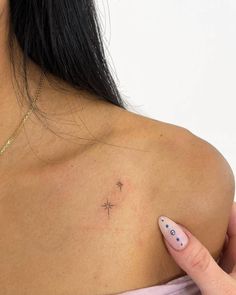 a woman with a small cross tattoo on her left shoulder, and a pink dress