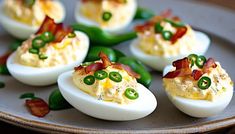 deviled eggs with bacon and green peppers on a plate