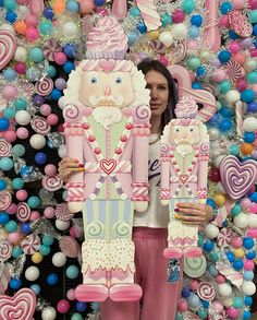 a woman standing in front of a display of candy decorations