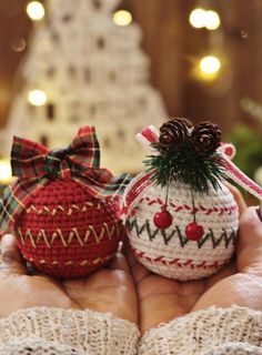 two knitted ornaments in the palm of someone's hand