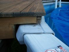 a close up of a wooden dock next to a swimming pool with water in it