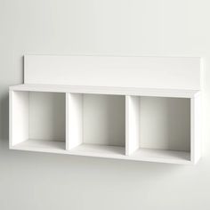 a white shelf with three compartments on the wall