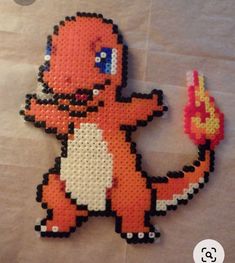 an orange and white pixel art piece sitting on top of a sheet of parchment paper