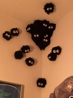 the wall is decorated with black and white fluffy balls, which look like they have eyes on them