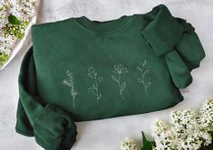 Botanical Minimalistic Wildflower Sweater 🌸 Looking for the perfect gift for your mom who loves nature and all things cozy? Our Botanical Wildflower Sweater is a heartfelt way to celebrate her unique style and love for the outdoors. Whether it's for Mother's Day, her birthday, Christmas, or for yourself, this beautifully embroidered sweater captures the essence of minimalistic wildflowers in a timeless, artistic way. Each delicate wildflower is embroidered with love, representing growth, beauty Floral Embroidered Sweater, Cute Embroidered Spring Sweater, Sweater With Embroidered Flowers, Cozy Long Sleeve Sweater With Floral Embroidery, Winter Floral Embroidered Sweater, Sweater Gift, Embroidered Sweater, Gifts For Your Mom, Autumn Cozy