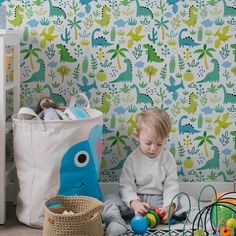 a toddler playing with toys on the floor in front of a dinosaur wallpaper