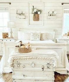 a bedroom with white furniture and pictures on the wall above it, along with an antique trunk