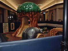 an elephant themed play area in the middle of a building with trees on it's roof