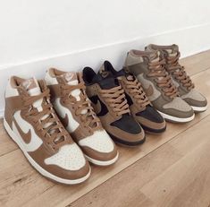 four pairs of sneakers are lined up on the floor