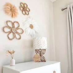 a white dresser with three decorative pieces on it