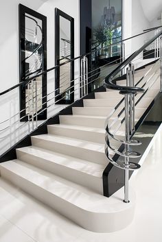 a set of white stairs with black railings and glass balconies on either side