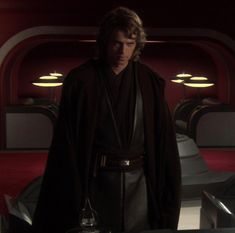 the star wars character is standing in front of a table with two lights on it