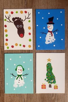 four christmas cards on a wooden table with snowmen, reindeer, and a tree