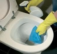 a person in yellow gloves cleaning a toilet