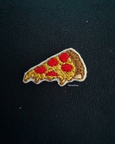 the embroidered patch has red and yellow flowers on it, along with a black background