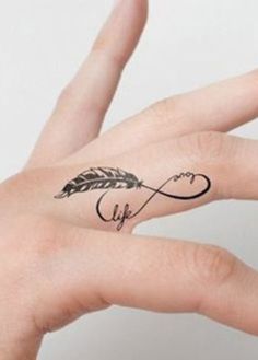 a person's hand with a tattoo that has an arrow and a heart on it