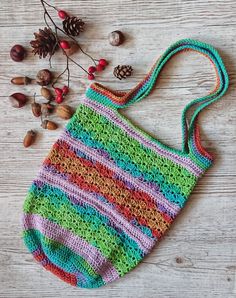 a multicolored crocheted bag sitting on top of a white wooden table