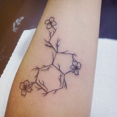 a tattoo on the leg of a woman with flowers growing out of her arm,