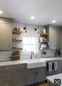 a kitchen with gray cabinets and white counter tops