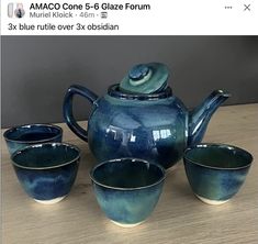 the tea set is blue and has four cups on it, with one cup in the middle