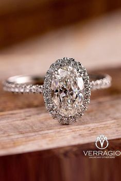 an oval cut diamond ring on top of a wooden table with the words verago written below it