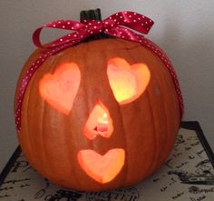 a carved pumpkin with hearts on it