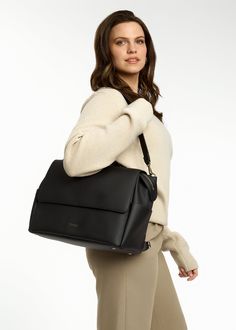 a woman carrying a black handbag on her shoulder