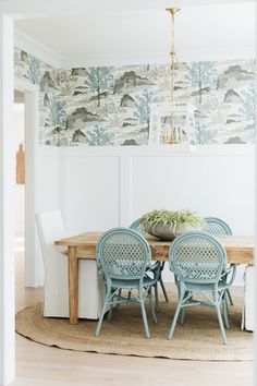 a dining room table with blue chairs and a potted plant on top of it