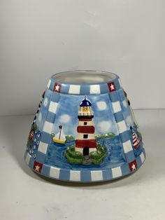 a blue and white lamp shade with a lighthouse on it