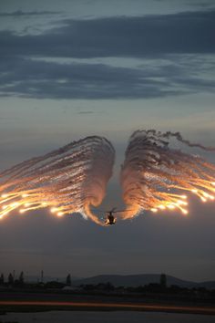 two planes are flying through the air with their wings spread out and lights on them