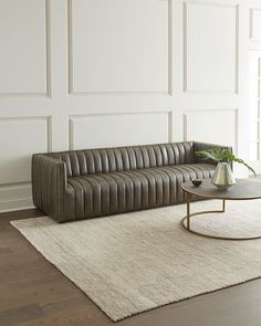 a living room with a couch, coffee table and rug