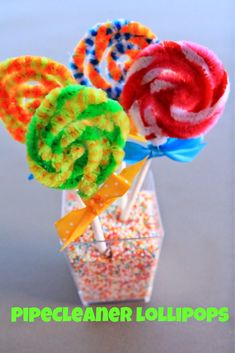 three lollipops in a vase with sprinkles