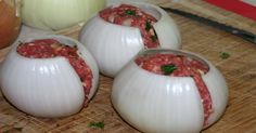 several different types of food being prepared on a cutting board, including onions and meatballs