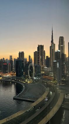 the city skyline is lit up at night, and there are many cars driving on the road