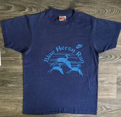 Nike Shirt 80's Vtg. Blue Heron Run. A rare tee. Vintage Nike tees often have rad graphics. This one is uniquely serene. There is a faint small mark on front. The shirt is super soft and overall in excellent condition! See more vintage Nike tees in my shop https://www.etsy.com/shop/sweetVTGtshirt?section_id=11916484&ref=shopsection_leftnav_4 Label: Hanes 50/50. USA Made Measurements: Inches Chest/Bust: 18 Bottom Hem: 18 Shoulders: 15 Sleeve: 6 1/2 Total length: 24 Size: Tag reads Medium. Run Marathon Shirts, Running Marathon, Nike Shirt, Nike T, Marathon Running, Blue Heron, Trendy Tee, Nike Tees, Nike Shirts