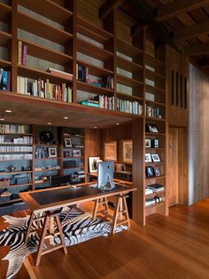 a home office with bookshelves, desk and zebra print rug