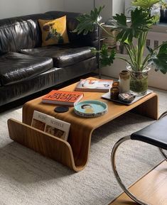 a living room with black leather couches and a wooden coffee table in the middle