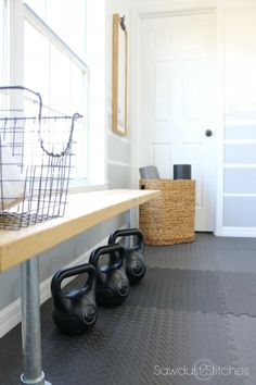 some black kettles sitting on top of a wooden table in front of a white door