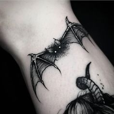 a black and white photo of a bat tattoo